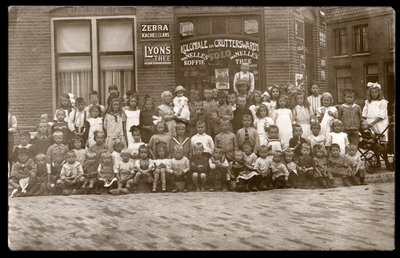 858792 Groepsportret met voornamelijk kinderen bij een winkel in koloniale waren te Utrecht, mogelijk in de omgeving ...